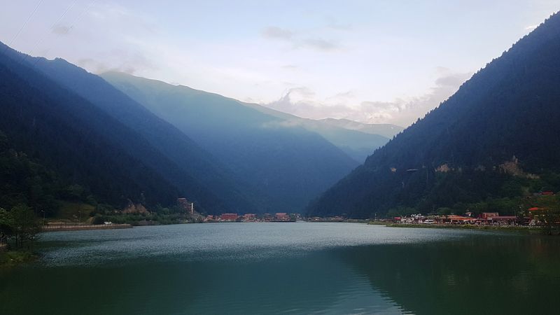 The still water of Uzungöl held between two forested slopes, with the range rising behind.