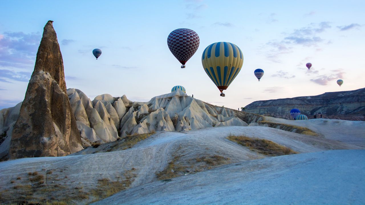 Hot-air balloons drifting above Cappadocia’s fairy chimneys at sunrise.