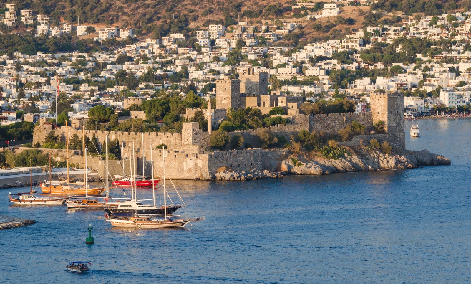 Bodrum Castle on its headland, with gulets moored in front and the white town behind.