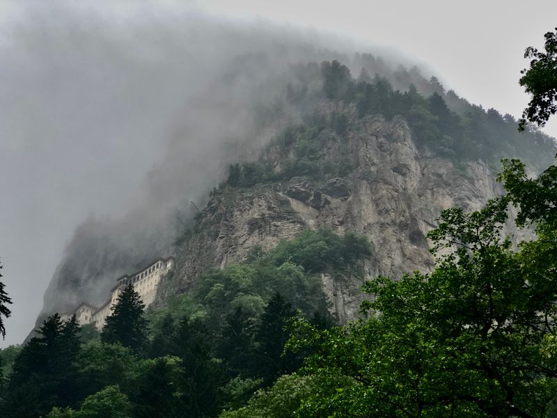 Sümela Monastery clinging to a misty, forested cliff above Altındere Valley.