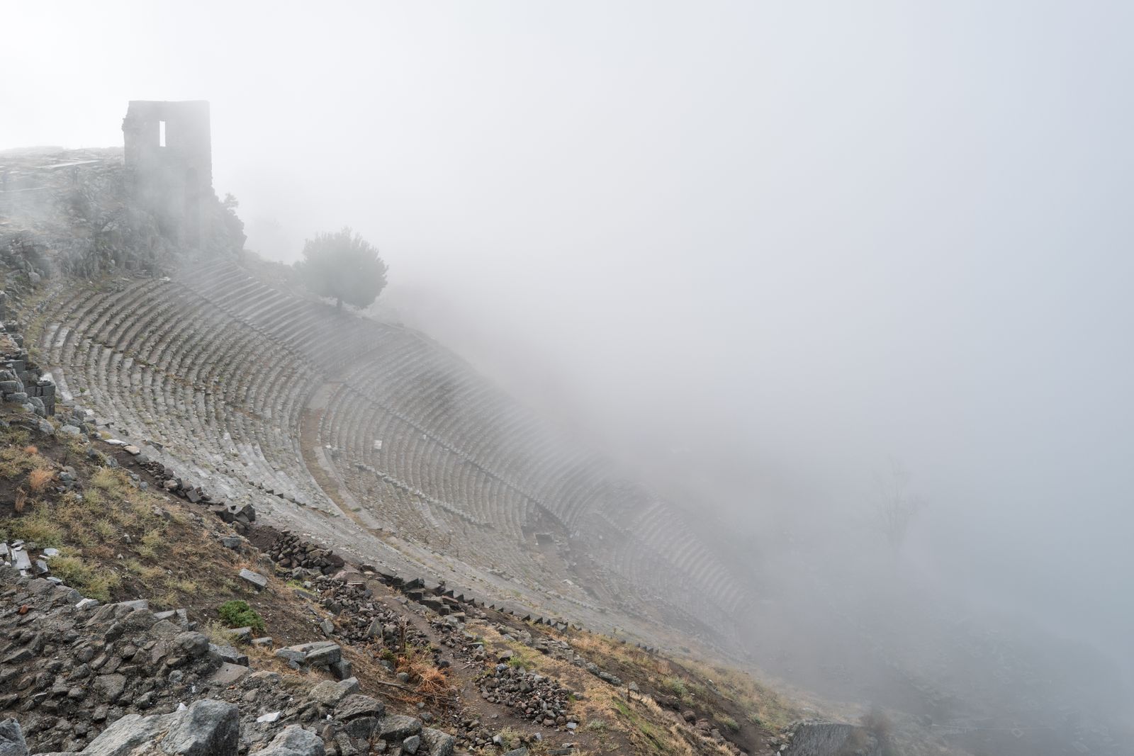 The ancient theatre cut into the steep slope of the Pergamon acropolis, in morning mist.