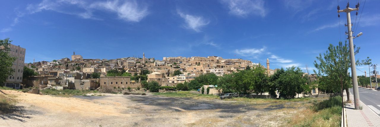 A wide panorama of Mardin’s stone-built city spreading across the hillside above the valley.