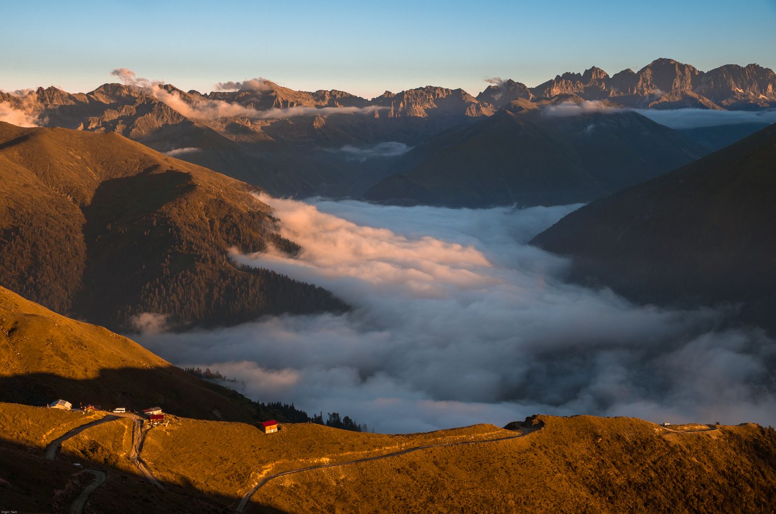 A sea of cloud filling the Avusor valley in the Kaçkar Mountains, with the peaks lit by low sun.